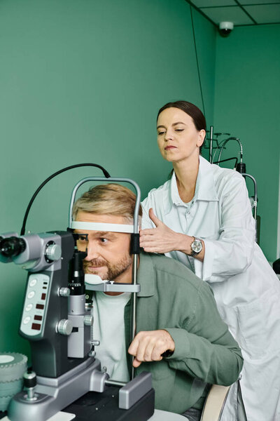 Woman examines mans eye with a microscope in doctors office.
