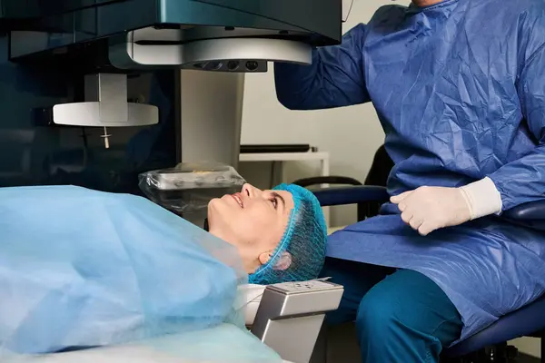青いガウンの女性は レーザービジョン補正スペシャリストによる医学検査を受ける — ストック写真