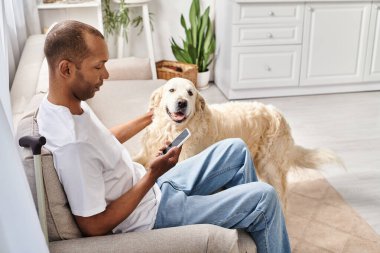 Özürlü bir Afrikalı Amerikalı adam, miastenya gravis 'i ile evde, sadık Labrador köpeğinin yanında dinleniyor..