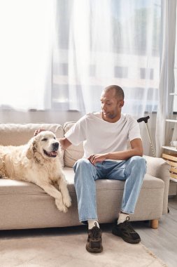 Miyastenia gravis 'i olan Afro-Amerikalı bir adam sadık Labrador köpeğinin yanındaki koltukta oturuyor..