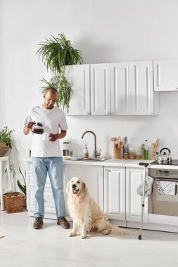 Mutfakta sadık Labrador köpeğinin yanında miastenya gravis 'i olan engelli bir Afrikalı Amerikalı..