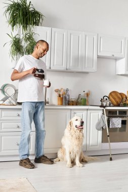 Miyastenia gravis 'i olan özürlü bir Afro-Amerikan erkeği sıcak bir mutfak ortamında Labrador köpeğinin yanında duruyor..