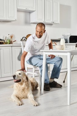 A disabled African American man sits at a table with his Labrador dog, both enjoying a peaceful moment together. clipart