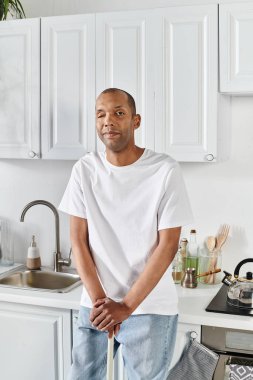 An African American man with myasthenia gravis syndrome stands confidently in a kitchen clipart