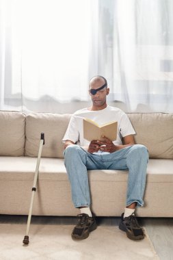 Afrika kökenli bir Amerikalı olan Myasthenia Gravis ile birlikte bir kanepede rahatça otururken kitap okumaya dalmış..