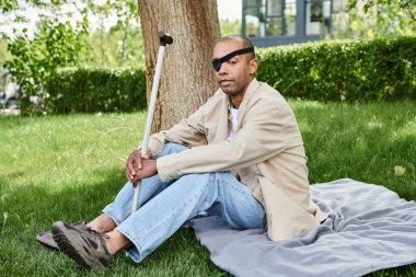 An African American man with myasthenia gravis syndrome relaxing on a blanket clipart