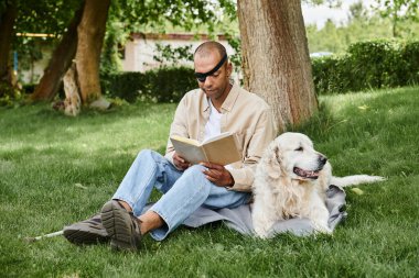 An African American man with myasthenia gravis sits in the grass reading while a loyal Labrador dog sits beside him. clipart