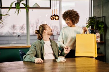 Two stylish women, one African American, sitting at a table with a shopping bag, chatting and admiring their new purchases. clipart