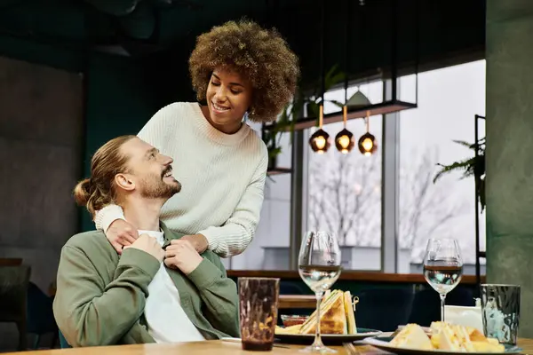 アフリカ系アメリカ人女性と男性がカフェでテーブルに座りながら会話に取り組んでいる — ストック写真