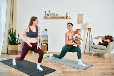 Genç, güzel bir anne ve bebeği, eğitmenin rehberliğinde evde yoga pozları veriyorlar..