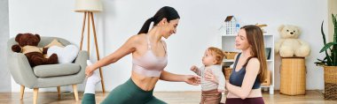 Spor sutyenli güzel genç bir anne ve tozluklu bir çocuk ile evde neşe içinde dans ediyor, ebeveynlik kursundan koçu rehberliğinde..