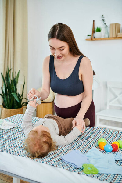 A young, beautiful mother interacts with her baby on a table, parents course.