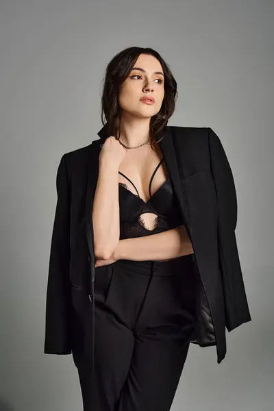 Beautiful Size Woman Black Suit Strikes Confident Pose Gray Backdrop — Stockfoto