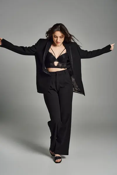 Beautiful Size Woman Stylish Black Suit Dances Gracefully Gray Backdrop — Stockfoto