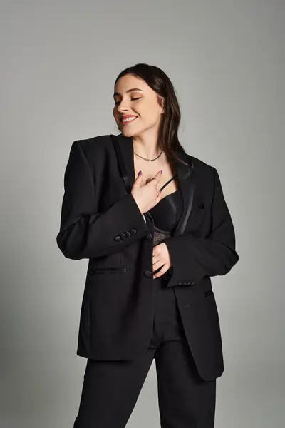 Stunning Size Woman Black Suit Confidently Posing Camera Gray Backdrop — Foto Stock