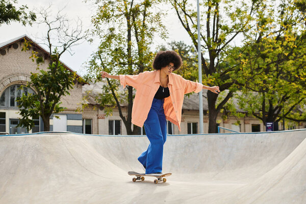 A young African American woman with curly hair rides a skateboard up the side of a ramp at an outdoor skate park.