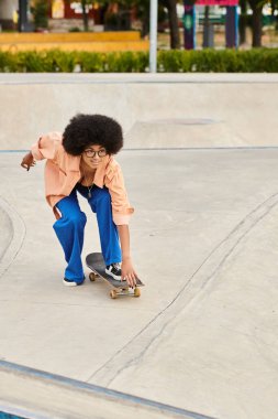 Açık hava kaykay parkındaki rampada kaykay yapan genç bir Afrikalı Amerikalı kadın etkileyici yetenekler sergiliyor..