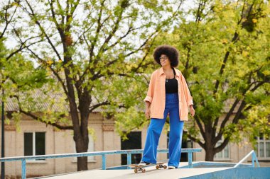 Young African American woman with curly hair skillfully riding a skateboard on top of a ramp at an outdoor skate park. clipart