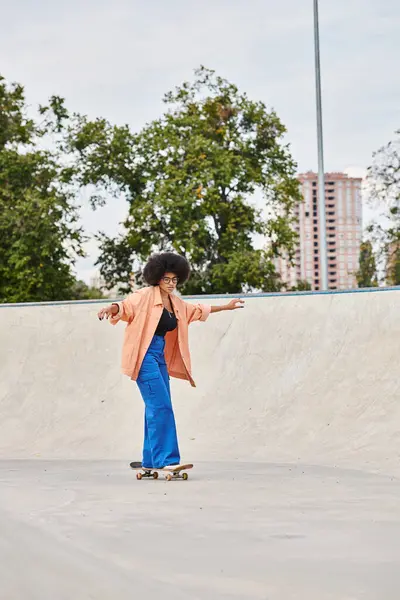 カーリーヘアを持つ若いアフリカ系アメリカ人女性は自信を持ってスケートパークで挑戦的なセメントランプの下にスケートボードに乗ります — ストック写真