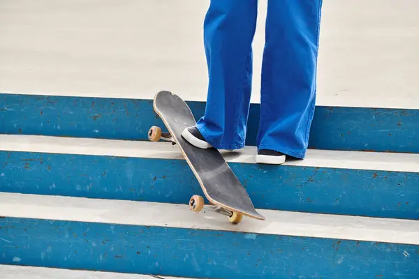 一名年轻的非洲裔美国妇女站在城市滑板公园的台阶上 巧妙地在滑板上保持平衡 — 图库照片