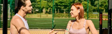Spor giyim sektöründe bir erkek ve kadın tenis kortunda, antrenörleri tarafından yönetiliyor, azim ve motivasyon gösteriyorlar..