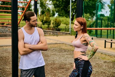A man and a woman in sportswear stand together outdoors, determined and motivated, supported by personal training clipart