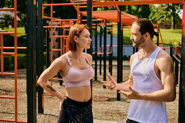 A woman in sportswear stand in front of a playground, working out with personal trainer.