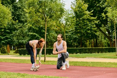Spor kıyafetli bir kadın çimenlerde kişisel antrenörüyle egzersiz yapıyor, azim ve motivasyon gösteriyor..