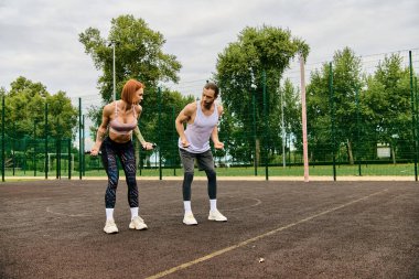 Spor giyimli iki atletik kadın bir tenis kortunun tepesinde güvenle duruyor, azim ve motivasyon gösteriyorlar..