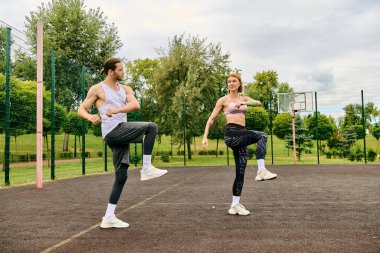 Spor giyimli bir kadın, şehir caddesinde kişisel antrenörüyle birlikte, azim ve motivasyon gösterisi yapıyor..