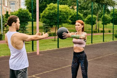Spor giyim sektöründe bir erkek ve kadın, dışarıda top oynayarak, azim ve motivasyon gösterisi yapıyor..