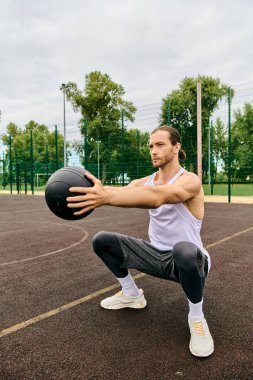 Spor giyim sektöründe bir adam sahada bir balo düzenliyor. Antrenmanlarında azim ve motivasyon gösteriyor..
