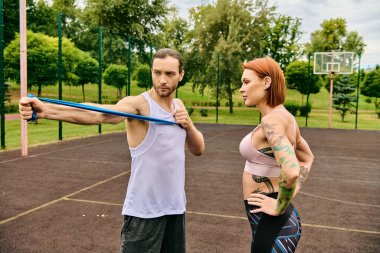Spor giyim antrenmanında bir kadın, kişisel antrenörüyle, azim ve motivasyon gösterisi yapıyor..