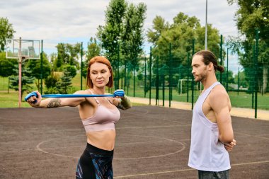 Spor giyim sektöründe bir kadın, kişisel antrenörle egzersiz yaparken azim ve motivasyon sergiliyor..
