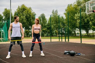 A man and woman in sportswear having resistance band training, showing determination and motivation clipart