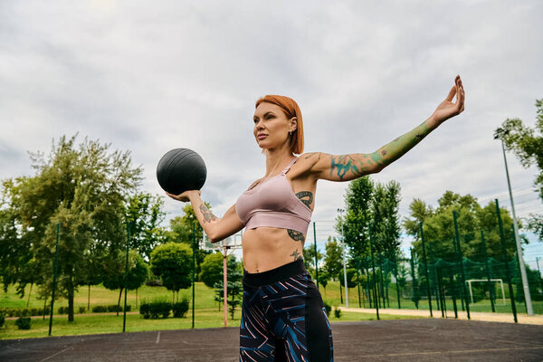 A determined woman in sportswear confidently holds a ball