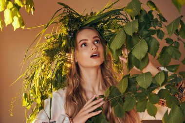 Geleneksel kıyafetli genç mavka, peri ve fantezi temalı stüdyo ortamında yemyeşil bir bitkinin önünde zarif bir şekilde duruyor..