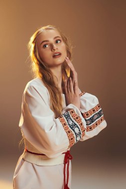 Beyaz elbiseli genç bir kadın ellerini zarif bir şekilde bir arada tutuyor. Huzur ve güzellik duygusunu somutlaştırıyor..