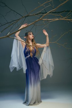 A young woman dressed in blue and white holds a delicate branch, embodying a fairy princess in a whimsical setting. clipart