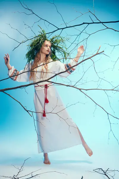 stock image A young mavka in a traditional outfit holding branches in a magical studio setting.