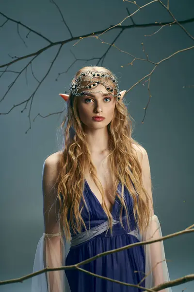 一位身穿蓝色衣服的年轻女子优雅地站在一棵雄伟的大树前 她的背景充满了异想天开的魔力 — 图库照片