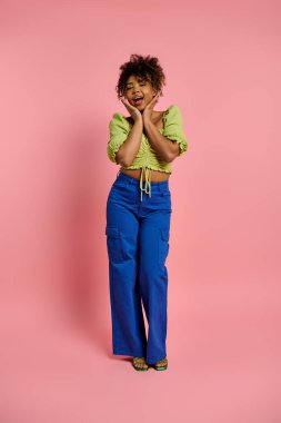 Zarif bir Afrikalı Amerikalı kadın canlı pembe bir arka plana karşı şık bir şekilde poz veriyor..