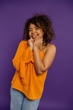 Tarz sahibi Afrikalı Amerikalı kadın, elleri çenesinde, duygularını belli ediyor..