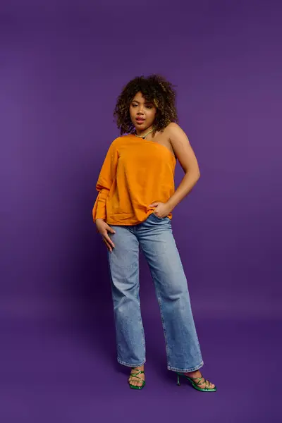 stock image Stylish African American woman standing gracefully against a vibrant purple backdrop.
