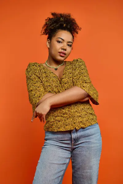 Afroamerikanerin Stilvoller Kleidung Die Arme Verschränkt Vor Leuchtend Orangefarbenem Hintergrund — Stockfoto