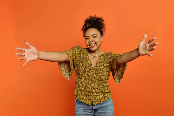 Stylish African American Woman Arms Outstretched Vibrant Orange Backdrop — Stok fotoğraf