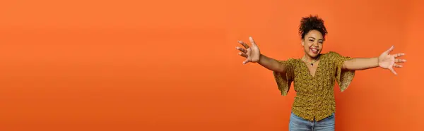 Man Extends Arms Front Vibrant Orange Background — Stok fotoğraf