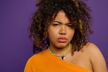 Kolye takan güzel bir Afro-Amerikan kadının yakın plan fotoğrafı. Parlak bir arkaplanda zarafet ve tarz yayıyor..