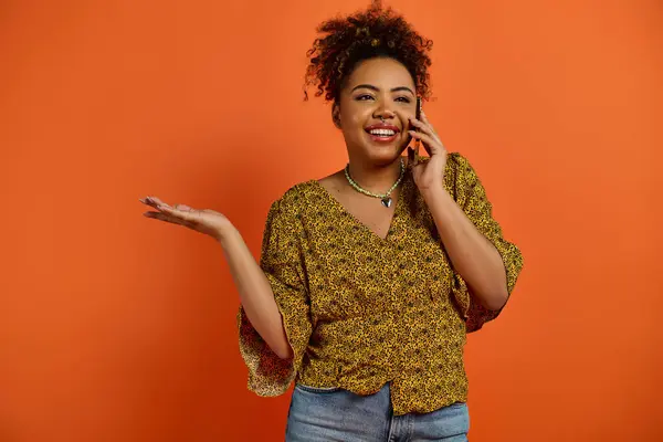 Stilvolle Afroamerikanerin Telefoniert Vor Orangefarbener Kulisse — Stockfoto