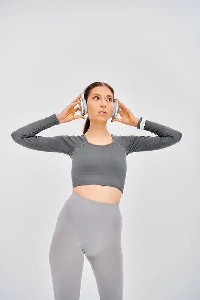 Sporty Young Woman Gray Top Grey Leggings Poses Confidently Grey — Stock Photo, Image